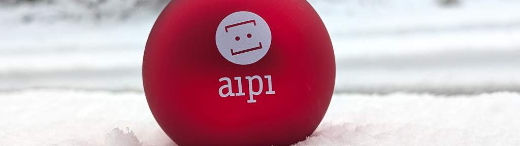 Weihnachtsbaumkugel in rot im Schnee vor dem Büro von aipi